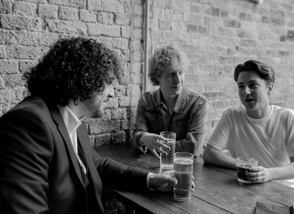 Three Brisbane locals talking at a pub